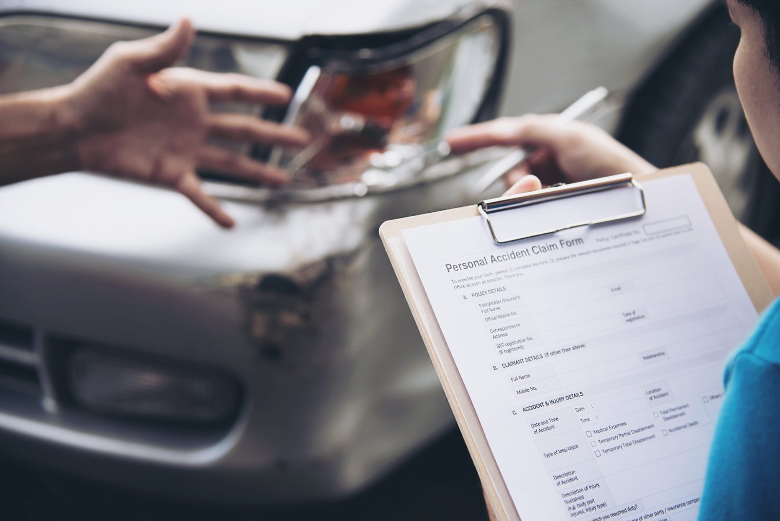 Insurance agent working during on site car accident claim process - people and car insurance claim concept
